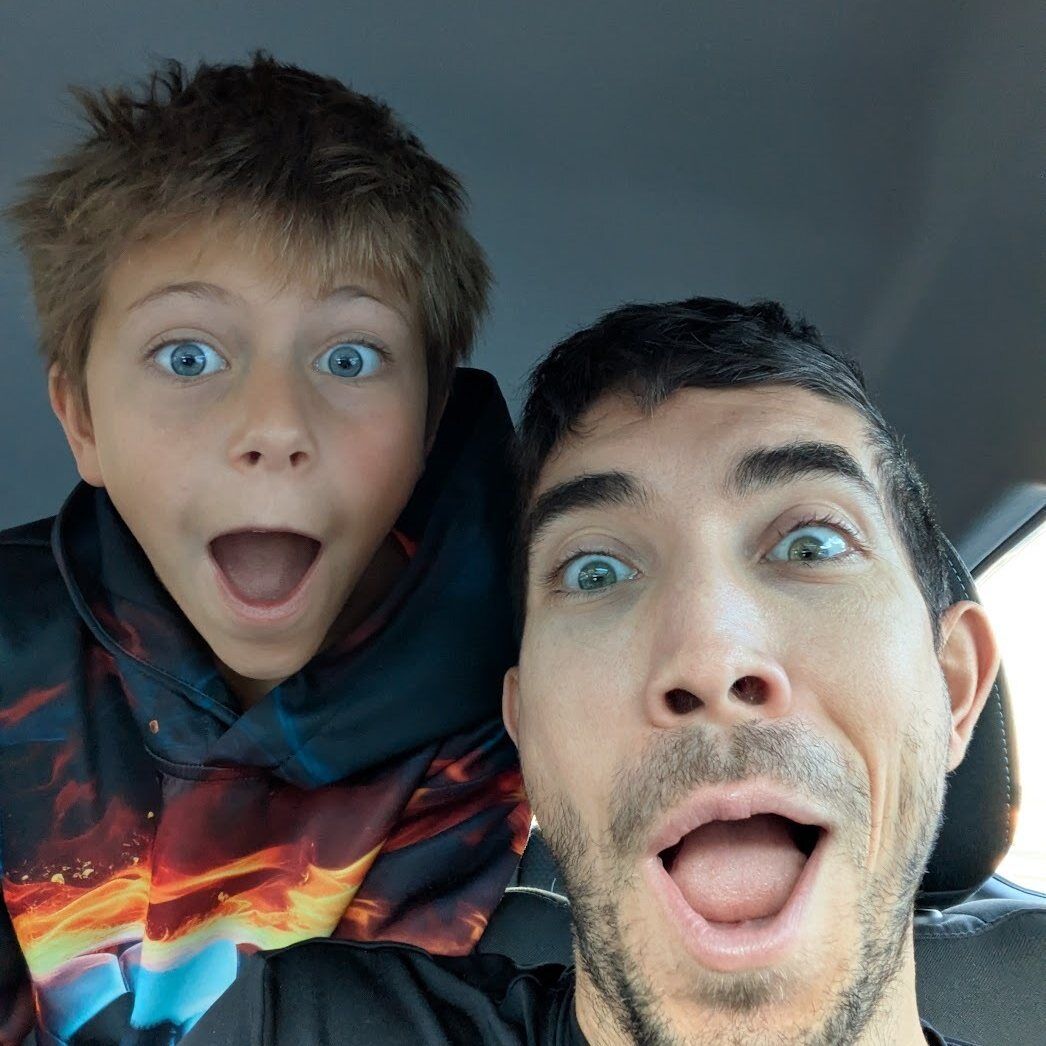 TC Schilling and his son side by side, both wide-eyed and open-mouthed at the camera.